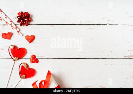 Arrière-plan avec cadeau, confetti et coeurs sucettes avec espace libre pour le texte sur fond en bois. Concept de la Saint-Valentin. Concept de fête des mères Banque D'Images
