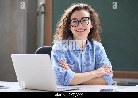 Jeune femme d'affaires heureuse assise au bureau avec ordinateur portable. Portrait Banque D'Images