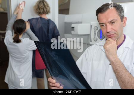 un médecin de sexe masculin regarde les rayons x. Banque D'Images