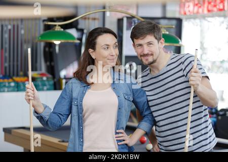 Jeune couple playing snooker ensemble dans bar Banque D'Images