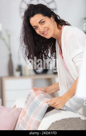 une jolie femme souriante qui a l'air de poser à la maison moderne Banque D'Images