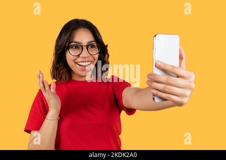 Jeune femme arabe mignonne utilisant un smartphone, prenant selfie Banque D'Images