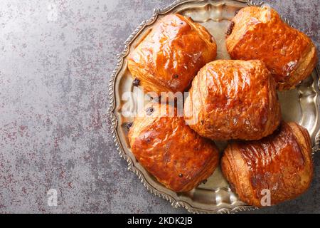 Croissants au chocolat faits maison pain au chocolat dans la plaque sur la table. Vue horizontale du dessus Banque D'Images