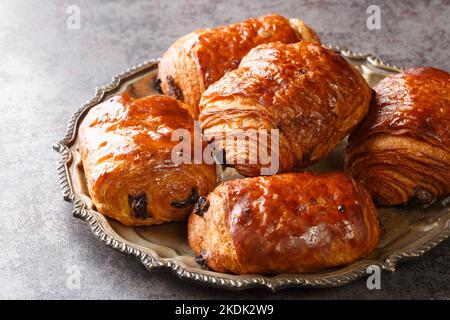 Croissants traditionnels français fraîchement préparés chocolat petit pain au chocolat tout près dans l'assiette sur la table. Horizontale Banque D'Images