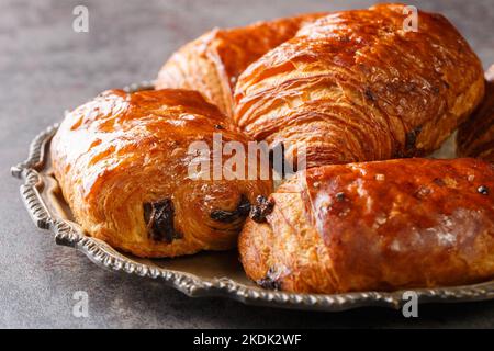 Croissants au chocolat faits maison pain au chocolat dans la plaque sur la table. Horizontale Banque D'Images