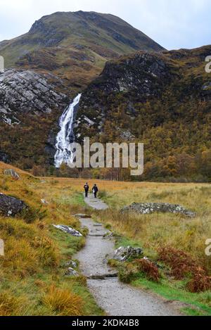 Cascade de Steall (les hautes chutes) à la tête de Glen Nevis, tombant des pentes d'un Gearanach dans les Mamores. Sentier avec deux randonneurs. Banque D'Images