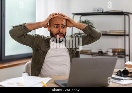 Oh non, concept d'erreur. Homme latin mature choqué utilisant un pc, en se secouant à la bouche ouverte et en attrapant la tête, assis au bureau Banque D'Images