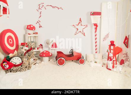 Voiture en métal dans une décoration de Noël avec d'autres objets rouges et blancs. Banque D'Images