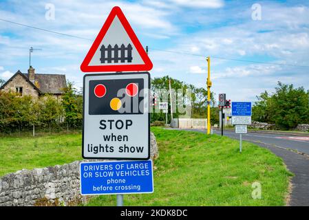 Panneaux de chemin de fer avant un passage à niveau à Arnside, Cumbria, Royaume-Uni. Banque D'Images