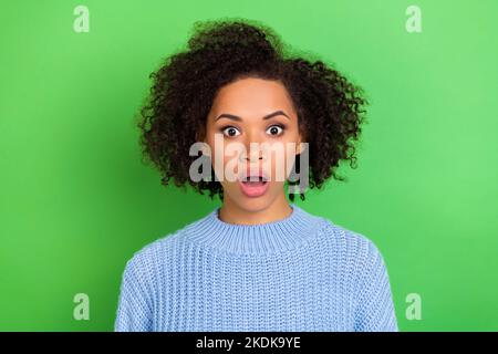 Photo d'une jeune femme impressionnée et surnommée avec son effigie ondulée porter un pull bleu à l'image d'un appareil photo isolé sur fond vert Banque D'Images