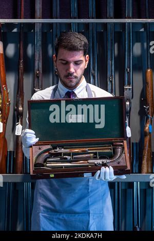 Londres, Royaume-Uni. 7 novembre 2022. Un technicien présente «Une paire de pistolets à percussion à percussion à 36 trous rare et à boîtier précoce» de J. Purdey, de Londres, nos 968 et 969, 1826, (est. £10 000 - £15 000) à un photocall de Bonhams Arms et armure qui comprend la collection Chris Wynn de Early Purdeys. La vente aux enchères aura lieu à Bonhams Knightsbridge le 9 novembre. Credit: Stephen Chung / Alamy Live News Banque D'Images