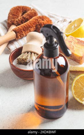 Produits et outils écologiques sans gaspillage pour le nettoyage de la maison. Pinceaux en bois, éponges à noix de coco, vinaigre en aérosol, soda, citron et savon biologique, dos gris Banque D'Images