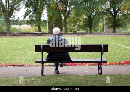 KNARESBOROUGH, Royaume-Uni - 20 septembre 2022. Homme plus âgé aux cheveux gris assis seul sur un banc de parc en automne. Knaresborough, Yorkshire, Royaume-Uni Banque D'Images