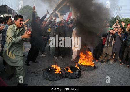 RAWALPINDI, PAKISTAN, NOVEMBRE 07: Les partisans du Pakistan Tehreek-e-Insaf (PTI) de l'ancien Premier ministre pakistanais Imran Khan flambeau se pneus pendant un pro. Banque D'Images