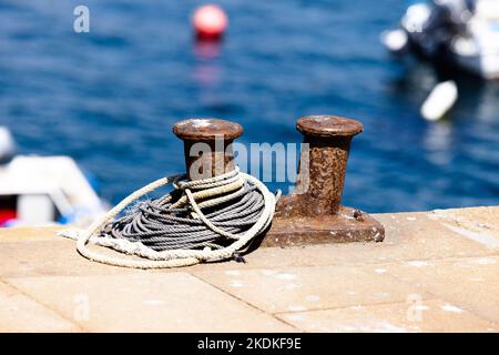 Gros plan de deux bollards marins rouillés sur la jetée dans un petit village de pêcheurs en Galice, Espagne Banque D'Images