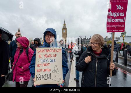 Une femme protestant avec un écriteau « 12 ans de gouvernement conservateur, ce que nous avons eu » avec une autre femme et une affiche « Refugees Welcome » devant Big Ben, Londres. Banque D'Images