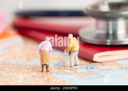 Concept de personnes miniatures de retraite ou de tourisme médical. Banque D'Images