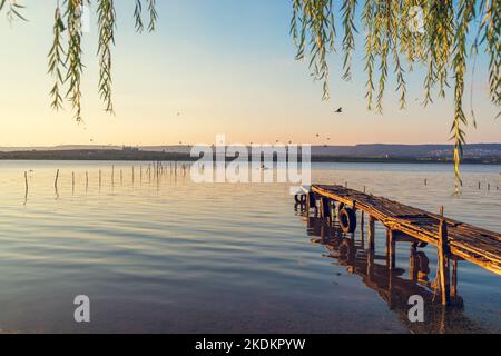 Coucher de soleil sur le lac de mer et ancienne jetée en bois, destination de voyage romantique, paysage de la nature Banque D'Images