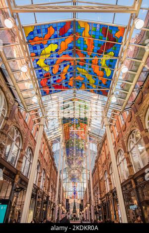 Arcade dans le quartier de Victoria, Leeds, Yorkshire avec des couleurs vives à motif abstrait verrière en bleu, jaune, rouge et vert, conçu par Brian Clark Banque D'Images