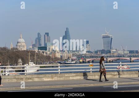 Londres, Royaume-Uni - 13 mars 2014 : une femme traversant le pont de Waterloo avec la Tamise, la cathédrale Saint-Paul, Gherkin et Walkie Talkie. Banque D'Images