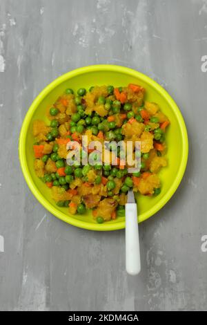 légumes mélangés pois, carottes, pomme de terre assiette enfant sur céramique Banque D'Images