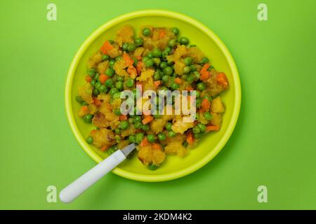 légumes mélangés pois, carottes, pomme de terre assiette enfant sur bleu Banque D'Images