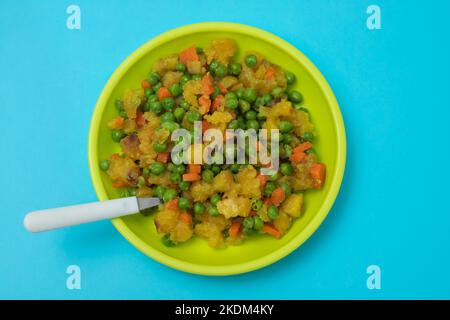 légumes mélangés pois, carottes, pomme de terre assiette enfant sur bleu Banque D'Images