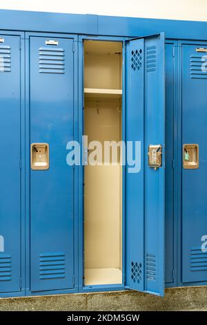 Casier métallique bleu ouvert le long d'un couloir non-exposant dans une école secondaire typique des États-Unis. Aucune information identifiable n'est incluse dans le hall. Banque D'Images