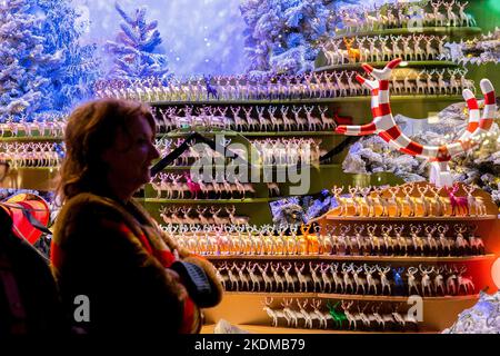 Londres, Royaume-Uni. 17th août 2022. Les gens ont vu regarder les vitrines décorées pour Noël à Regent Street à Londres. Dans certaines rues de Londres, les lumières de Noël ont été allumées sur 2 novembre. Le Royaume-Uni a été averti de la possibilité de faire des coupures cet hiver dans le scénario peu probable de panne d'électricité. Le quartier commerçant d'Oxford Street est régulièrement exposé de façon éblouissante tout au long de la journée et de la nuit. Cependant, cette année, dans une tentative de consommer moins d'énergie et d'économiser de l'argent, ils ne s'allument que de 3:00 à 11:00. Crédit: SOPA Images Limited/Alay Live News Banque D'Images