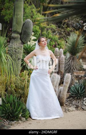 Mariée debout dans un jardin de Cactus Banque D'Images