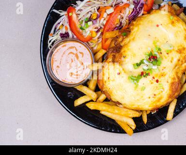 Frites, hacher la viande au fromage, coleslaw. Nourriture savoureuse. Plaque noire Banque D'Images