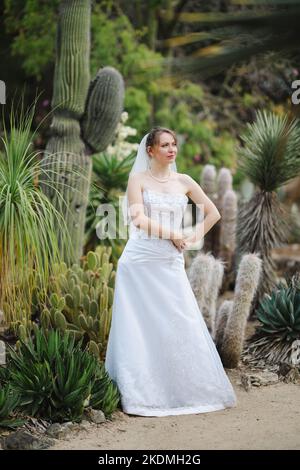 Mariée debout dans un jardin de Cactus Banque D'Images