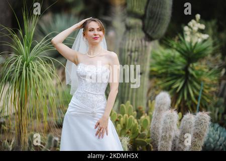 Mariée debout dans un jardin de Cactus Banque D'Images