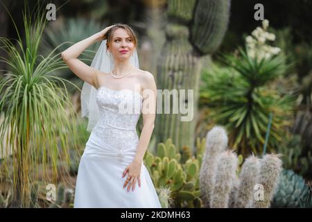 Mariée debout dans un jardin de Cactus Banque D'Images