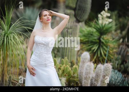 Mariée debout dans un jardin de Cactus Banque D'Images