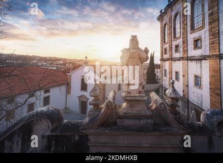 Statue de Minerva au sommet de l'escalier de Minerva et de la chapelle de Santo Antonio à l'université de Coimbra au coucher du soleil - Coimbra, Portugal Banque D'Images