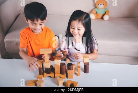 Enfants garçon et fille jouant avec constructeur en bois bloc bâtiment Banque D'Images