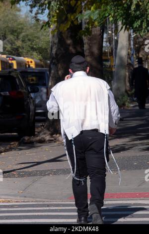 Un juif orthodoxe anonyme portant son tallis katan tzitzit sur sa chemise. Un doux jour d'automne à Brooklyn, New York. Banque D'Images