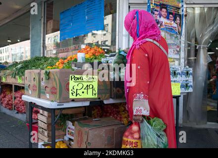 Une femme portant un hijab et masque pour Pohi Saag légumes au supermarché Apna sur 37th Avenue à Jackson Heights, Queens, New York. Banque D'Images