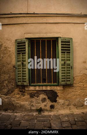 Une fenêtre barrée dans un ancien bâtiment résidentiel du centre historique de Piran sur la côte slovène Banque D'Images