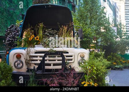 Moscou, Russie - 30.07.2022: Un vieux camion bleu rempli d'une variété de plantes et de fleurs. Lit de fleurs à Moscou, Russie. Banque D'Images