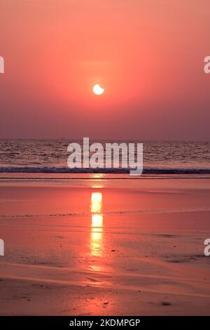 Vagues de mer précipitées illuminées par le rétrécissement du faisceau de soleil éclipsé Banque D'Images