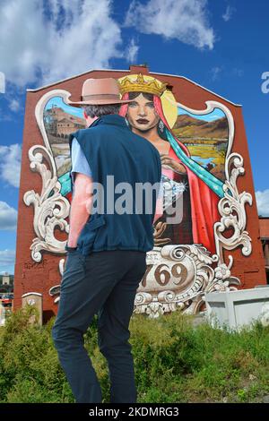 Un homme pond une énorme peinture murale à l'arrière d'un bâtiment en cours de rénovation sur River St. dans le centre-ville de Wilkes barre, Pennsylvanie. Banque D'Images