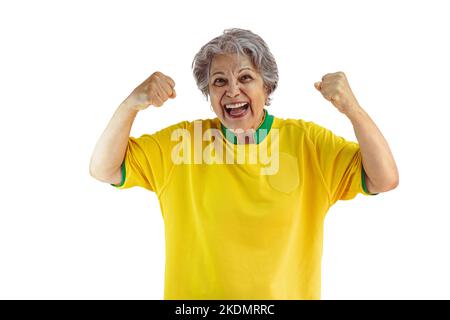 Femme mature avec maillot jaune de l'équipe de football isolé sur blanc. Fan de sport avec drapeau célébrant la coupe. Banque D'Images