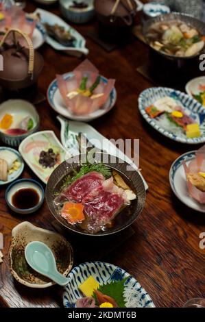 Un repas traditionnel japonais ryokan, composé de sukiyaki cuisiné en portions individuelles et de produits de saison, au Chojukan Ryokan, Hoshi Onsen, Gunma Banque D'Images