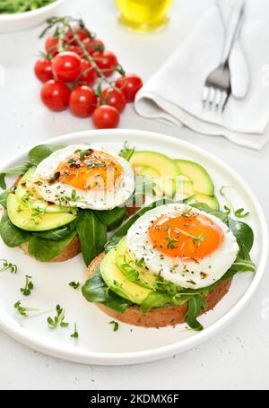 Pain avec œufs frits, avocat et légumes verts, vue rapprochée Banque D'Images