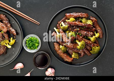 Le bœuf et le brocoli braissent sur fond sombre. Vue de dessus, plan d'appartement Banque D'Images