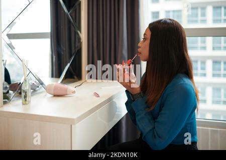 Élégante femme entrepreneur appliquant le maquillage le matin Banque D'Images