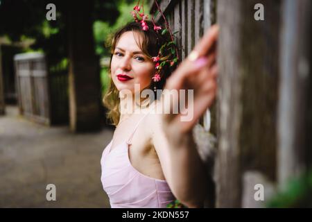 Femme portant un Rose Gown visitant un jardin idyllique Banque D'Images