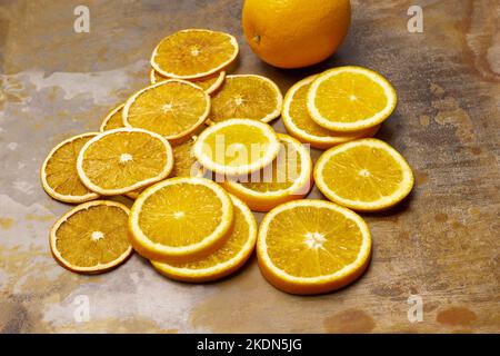 Tranches d'orange sèches et tranches d'orange fraîches. Orange frais entier. Vue de dessus. Arrière-plan en métal rouillé. Banque D'Images